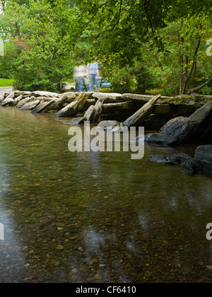 Menschen überqueren den Fluss Barle über Tarr Steps, eine antike Klöppel Brücke im Exmoor National Park. Stockfoto