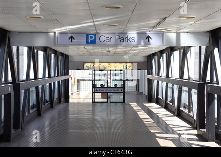 Einfahrt zum Parkplatz. Glastüren, Sonnenlicht durch große Fenster scheint Stockfoto