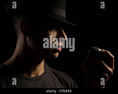 Sänger mit schwarzen Fedora Hut und Shure 55 Mikrofon Stockfoto