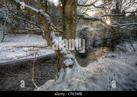 Sonnenuntergang über ein Nebenfluss des Flusses Wear, mit beiden Ufern mit Schnee bedeckt. Stockfoto