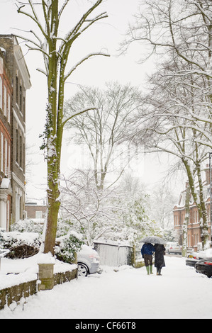 Ein paar entlang Schnee bedeckt Straßen in Camden. Stockfoto