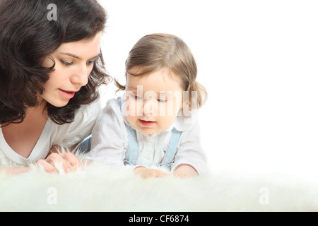 Nachdenklich Mutter und ihrer kleinen Tochter liegen auf weißen flauschigen Teppich Stockfoto