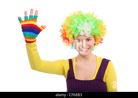 Lustiges Mädchen in farbigen Lockenperücke zeigt Hand in multicolor Handschuh Stockfoto