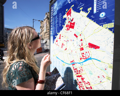 Frau, Blick auf eine Karte in den Straßen von Manchester. Stockfoto