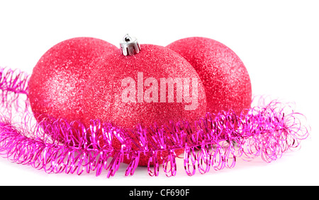Drei rote Christbaumkugeln umgeben von lila Lametta, Fokus auf vorderen ball Stockfoto