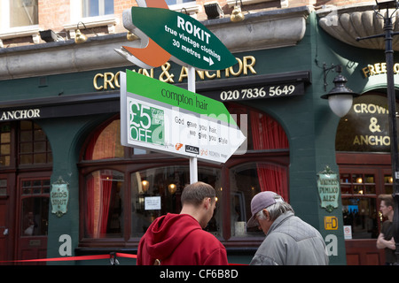 Junger Mann Wegbeschreibungen in Covent Garden außerhalb der Crown and Anchor Pub. Stockfoto