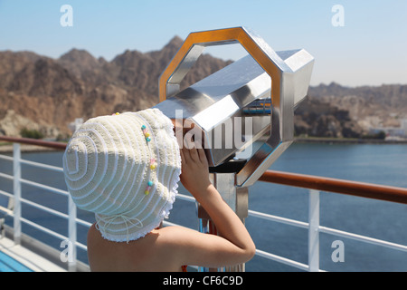 kleines Mädchen mit Panama Hut blickt auf Teleskop auf dem Deck des Schiffes Stockfoto