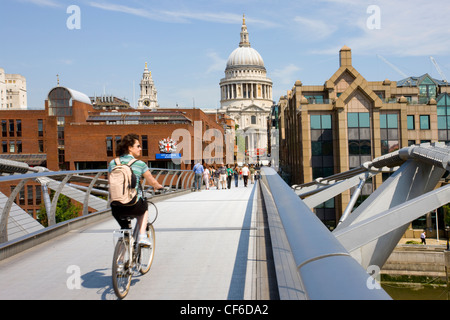 Ein Radfahrer, der Millennium Bridge in Richtung St. Pauls Cathedral auf der Nordseite der Themse überqueren. Stockfoto