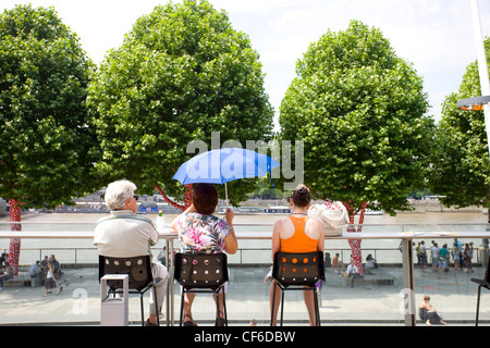 Menschen sitzen auf dem Balkon in der Royal Festival Hall mit Blick über den Fluss Themse. Stockfoto