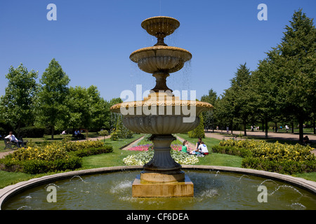 Menschen sitzen von einem Brunnen im Regents Park. Stockfoto