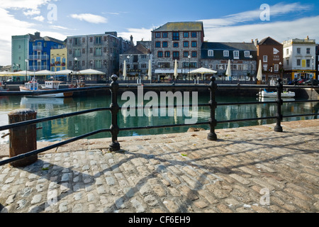 Blick vom gepflasterten Hafenpromenade über den Hafen von Pubs und Restaurants in Plymouth regenerierten Barbican. Stockfoto