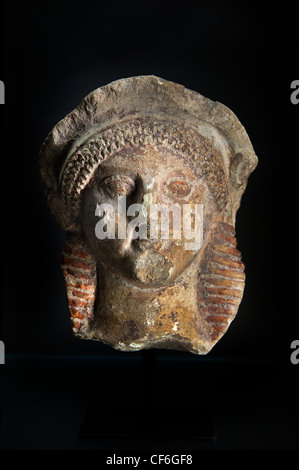 Antike griechische Kalksteinskulptur aus dem 6. Jahrhundert v. Chr., die einen diademgeschmückten Frauenkopf darstellt, mit archaischen Merkmalen und Spuren von polychromen Pigmenten Stockfoto