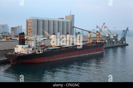 Große Ladung Schiff angedockt, Industriehafen am Abend in Abu Dhabi Stockfoto