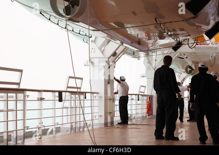 Service-Personal in schwarzer uniform stehen auf cruise Liner Deck, Ansicht von hinten Stockfoto