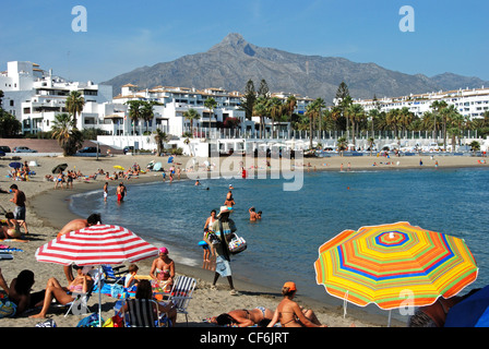 Urlauber am Strand von Playa de Nueva Andalucia, Puerto Banus, Marbella, Costa Del Sol, Provinz Malaga, Andalusien, Spanien. Stockfoto