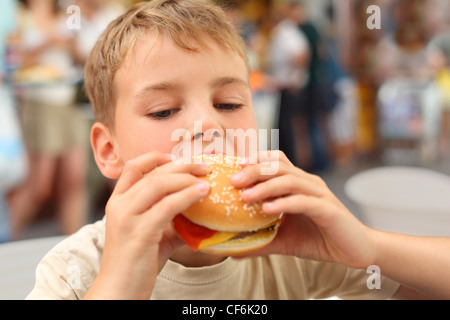 kleinen kaukasischen jungen Essen Burger, Blick nach unten Stockfoto