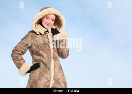 Schönes Mädchen steht im Winter Mantel mit Kapuze Stockfoto