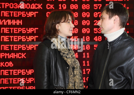 Mann und Frau in Leder Jacke im Profil stehen und zueinander in Augen auf Grund der Flugplan Stockfoto
