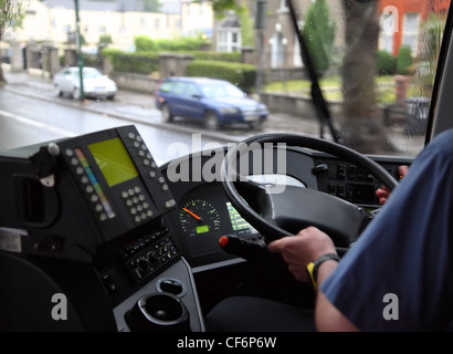 Mann im blauen Hemd in einem Bus auf einer nassen Straße an einem regnerischen, trüben Tag reiten Stockfoto