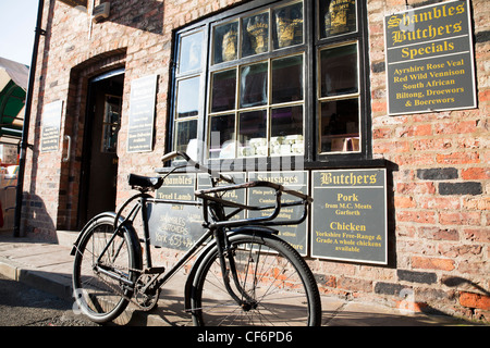 York City, Yorkshire, England Trümmern Metzger in der legendären Trümmern mit traditionellen Metzger Fahrrad außerhalb Stockfoto