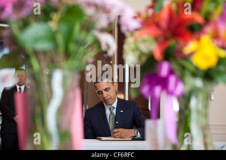 Präsident Barack Obama unterzeichnet ein Kondolenzbuch für Japans Erdbeben und Tsunami-Opfer in der Botschaft von Japan 17. März 2011 in Washington, DC. Japanischer Botschafter in den Vereinigten Staaten Ichiro Fujisaki steht auf der linken Seite. Stockfoto