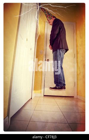 Mann trägt Dunce Cap in Ecke schweben. Stockfoto
