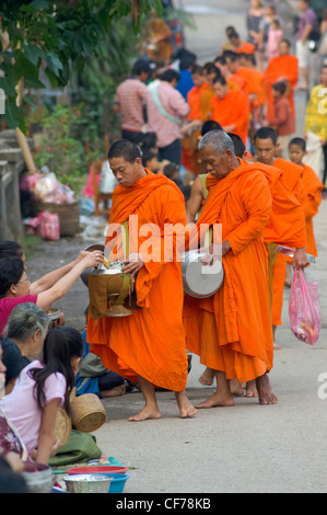 Buddhistische Mönche auf ihre Morgen Almosen Runde am ersten Tag des neuen Jahres, Lao Neujahr (Pi Mai Lao), Luang Prabang, Laos Stockfoto