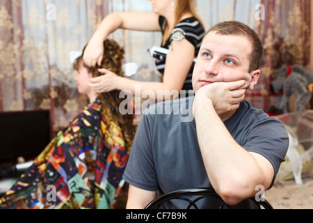 Müde kaukasischen russischen Bräutigam Braut wartet, während der Hochzeitsvorbereitungen in Wohnraum Stockfoto