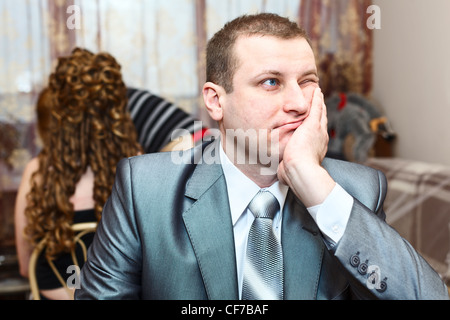 Müde kaukasischen russischen Bräutigam Braut wartet, während der Hochzeitsvorbereitungen in Wohnraum Stockfoto