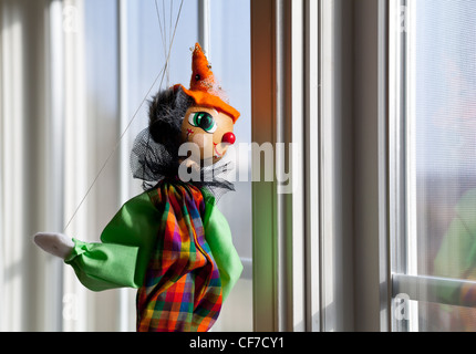 Marionette oder Marionette hängen im Fenster und blickte außerhalb in sonnigen Außenbereich Stockfoto