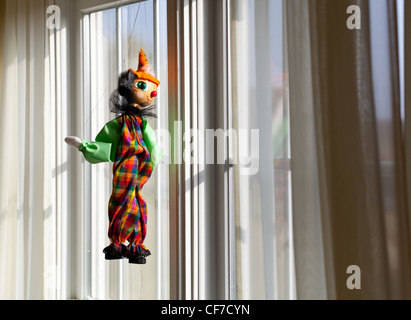 Marionette oder Marionette hängen im Fenster und blickte außerhalb in sonnigen Außenbereich Stockfoto