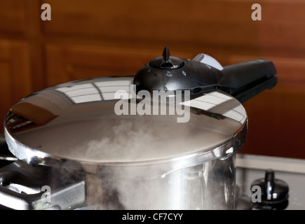 Schnellkochtopf Freigabe Dampfdruck auf Kochfeld in modernen Küche Stockfoto