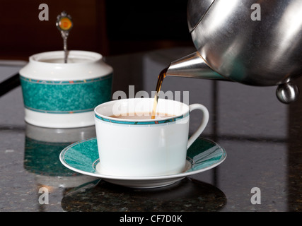 Frischer Tee auf Marmor Küchenarbeitsplatte in weißen Tasse gegossen Stockfoto