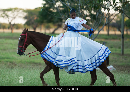 Eine traditionelle Frau Tänzerin auf einem Pferd in Tracht Guanacaste Person mit mehr Frauen zu tanzen. Stockfoto