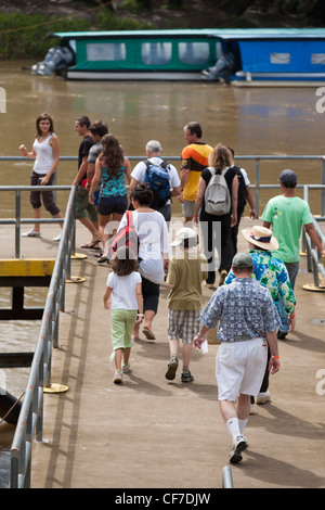 Passagiere laufen Sie das Dock zum Boot die Touristen auf einer Tour durch Rio Sarapiqui in Puerto Viejo de Sarapiqui in Costa Rica Stockfoto