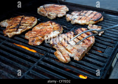 Schweinekoteletts beim Grillen im Freien. Stockfoto