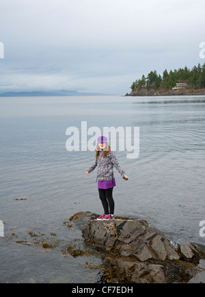 Junges Mädchen auf den Felsen am Meer Seacreast Nanoose. Vancouver Island. Britisch-Kolumbien. Kanada. SCO 8065 Stockfoto