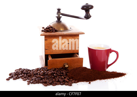 Alte hölzerne Kaffeemühle mit Bohnen und Tasse auf weißem Hintergrund Stockfoto