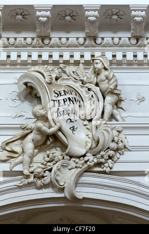 Innenraum der Chiesa di San Carlo Borromeo al Corso in Noto: dekorative Formen über einen Bogen mit Putten halten eine Schriftrolle Stockfoto