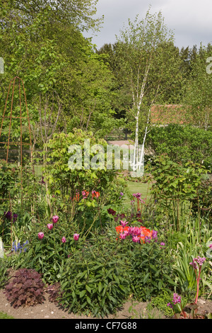 Das Graben Garten Beet mit Tulpen und anderen Pflanzen Stockfoto