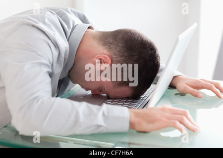 Nahaufnahme eines überarbeiteten Geschäftsmann ein Nickerchen auf seinem laptop Stockfoto
