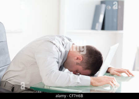 Überarbeitete Geschäftsmann ein Nickerchen auf seinem laptop Stockfoto