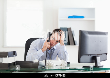 Geschäftsmann versucht, ein Problem am Telefon zu lösen Stockfoto