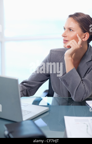 Porträt von zweifelhaften Geschäftsfrau mit einem Laptop arbeiten Stockfoto
