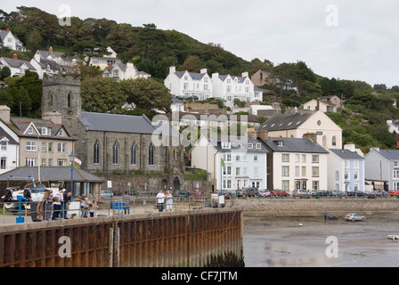 Familien-Krabben fischen an der Pier in Aberdovey vor bunte Strandhäuser vorne und St.-Peter Kirche, Aberdyfi, Wales, UK Stockfoto