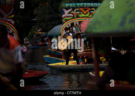 Mariachi Musiker spielen mexikanische Lieder für Touristen in einem Boot durch die Wasserkanäle von Xochimilco auf der Südseite von Mexiko Stockfoto