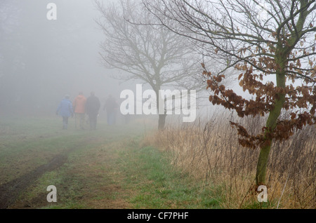 Gruppe der Wanderer im Nebel auf einer Land-Strecke Stockfoto