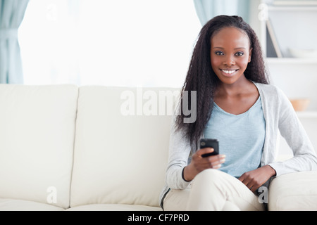 Frau auf dem Sofa Textmitteilung zu schreiben Stockfoto