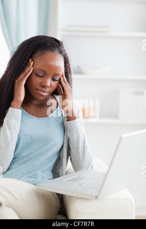 Nahaufnahme von Laptop gibt Frau Kopfschmerzen Stockfoto