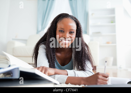 Frau liegt auf dem Teppich, Hausaufgaben Stockfoto